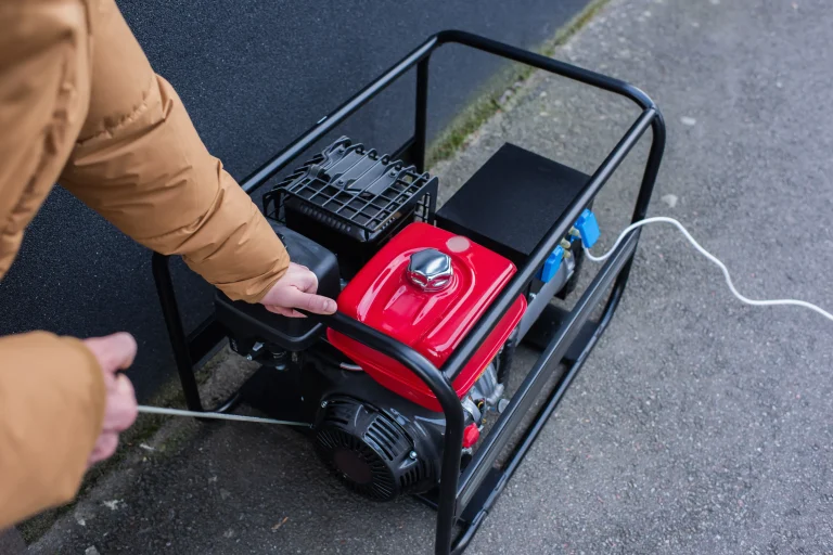 A man getting a generator to start by pulling the start string.