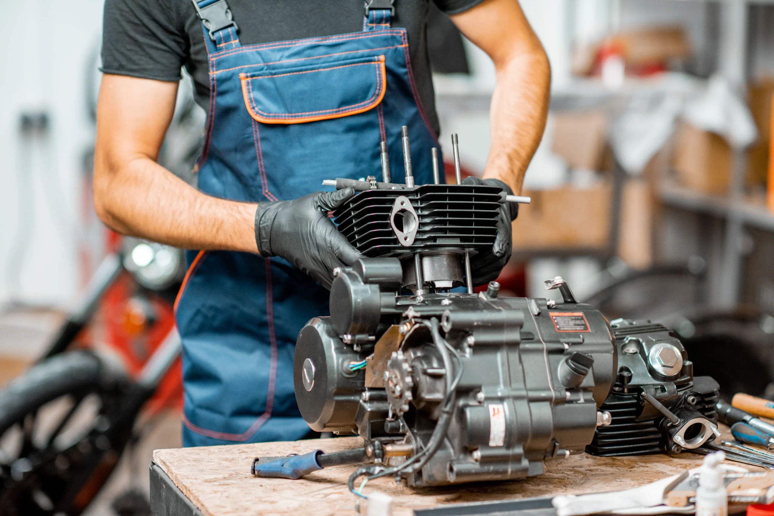 A man repairs the engine of a motored machine.
